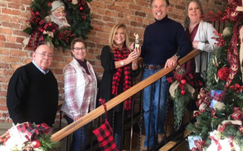 Tracie Griffith, holding trophie, presents a third place trophie to Coldwell Banker. From left, Steven Cockburn, Donna O’Neal, Tracie Griffith, Faron King and Teresa Cronk smile while accepting the award.