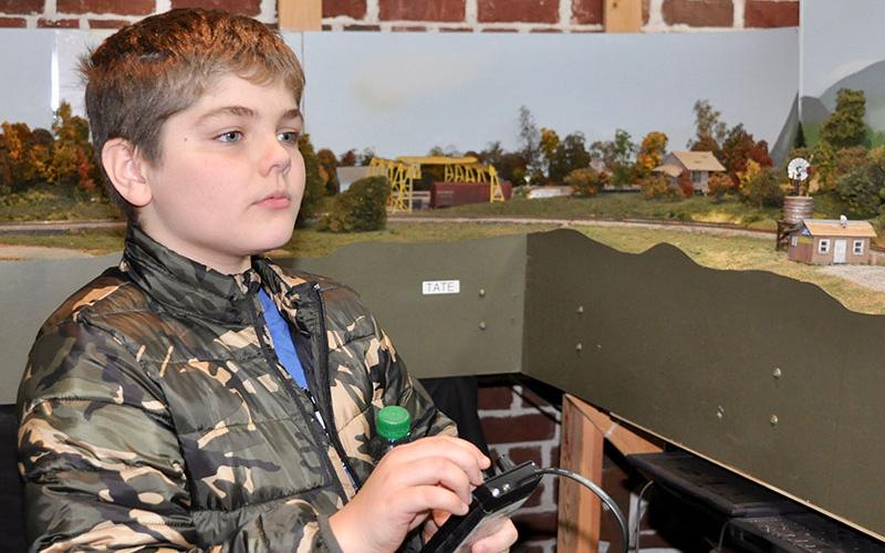 Jake manuevered his train through the model City of Blue Ridge as visitors watched at Tri-State Model Railroaders Christmas Season Open House Saturday, December 28.