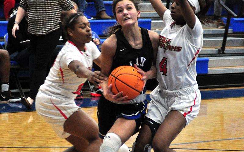 Lady Rebel Becca Ledford fights through two GAC defenders in recent action for the Lady Rebels basketball team.