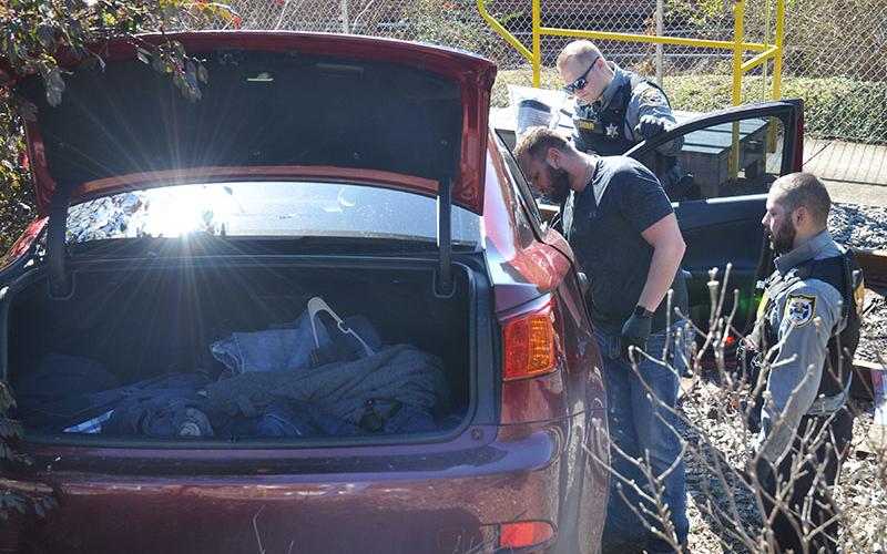 Polk County Sheriff’s Office deputies, from left, Detective Josh Stroud, Deputy Manuel Patterson and Deputy Kelby Liner search the car driven by Matthew Alexander Rich.