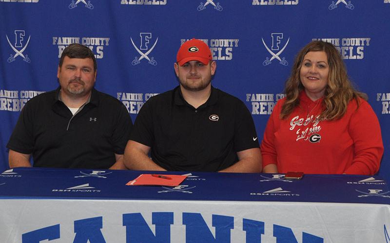 Fannin County Rebel Miles Johnson chose to further his academic and football career Wednesday, February 5, when he signed to become a preferred walk on at the University of Georgia. Pictured are, from left, Earl Johnson, father; Miles Johnson and Leslie Mann, mother.