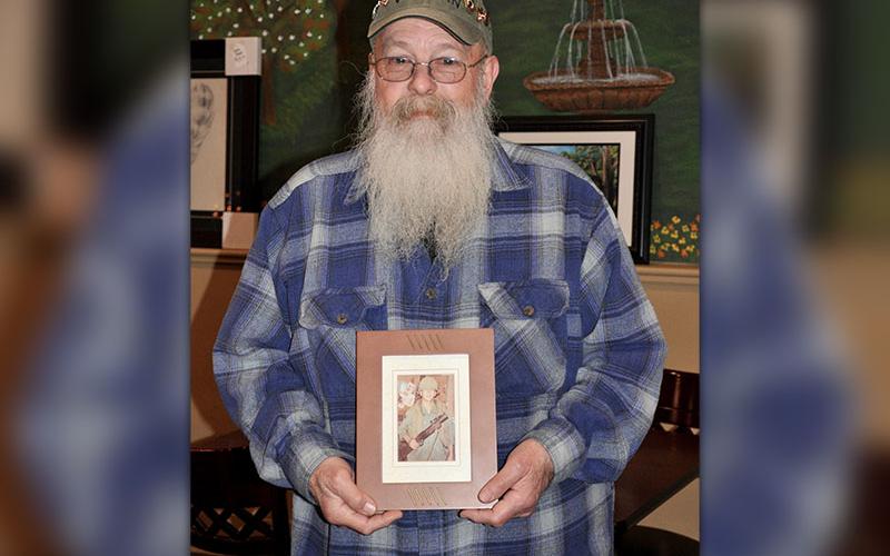 U.S. Army Vietnam Veteran Chuck Bowen III holds a photograph of himself during his time in service Wednesday, January 29.