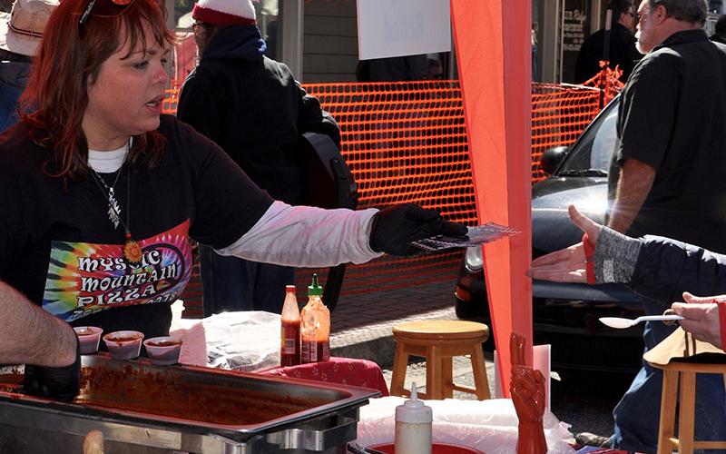 Restaurateur Brannen Mathis gives a stamped chili card back to a patron before handing out her chili Saturday, February 15.