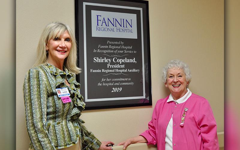 Fannin Regional Hospital Auxiliary president Shirley Copeland, right, stands next to a mounted award recognizing her service to Fannin Regional Hospital and the community during the year of 2019. She is shown with Director of Volunteer Services Susan Kiker.