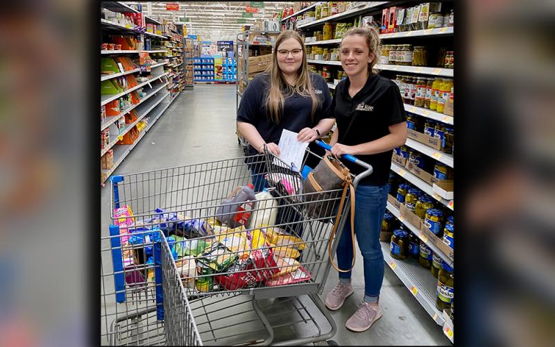 Hannah Ritchie, left, and Ashton Davis are shown gathering groceries for an elderly woman Thursday, March 26. The elderly woman could not go out and get essentials and had no one to make the trip for her.