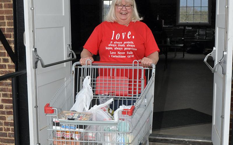 Kathi Hensley was all smiles as she went about getting groceries to families last week at the Hoist House.