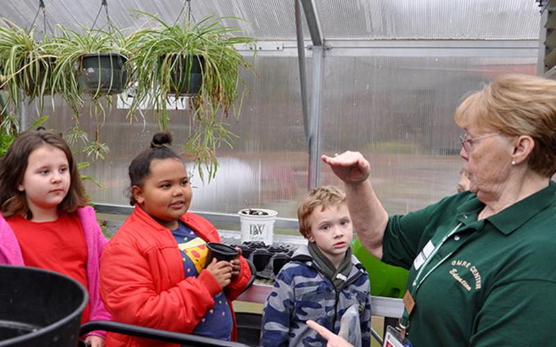 Master Gardener Denise Atkins, right, instructs East Fannin Elementary students on how to plant their seeds during a special class Monday, March 2. Listening attentively are, from left, Hadley Queen, Memori Sorensen and Cullen Kimsey.