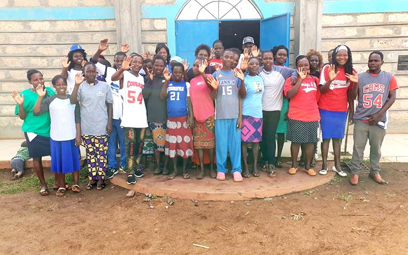 Tharaka-Nithi County, Kenya children wave to the camera while wearing their new Copper Basin and Fannin County sports shirts, donated by Tim and Debbie Smith of North Georgia Sports Zone.