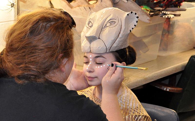 West Fannin Elementary School student Sadie Navarro has her face painted by Choreographer Carolyn Gibbs to prepare for a dress rehearsal Monday, March 4.
