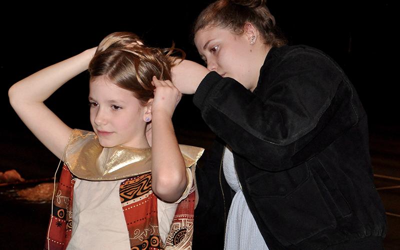 West Fannin Elementary Student Allie Rosa Radabaugh has her headset adjusted by Fannin County High School student and theater tech Hailey Fields during a dress rehearsal for The Lion King Wednesday, March 4.