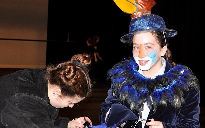 West Fannin Elementary School student Megan Jones has her microphone mounted by Fannin County High School student and theater tech Hailey Fields.