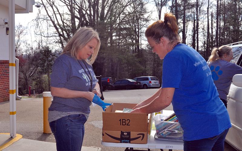 Fannin County School System staff members Jill Holloway, left, and Wendi Hood help prepare meals for Fannin County students to have during school closures Thursday, March 19.
