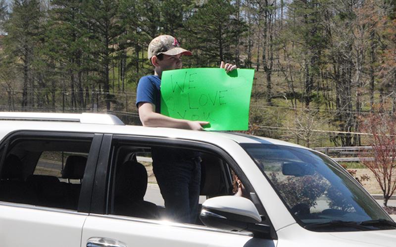 Parade participants held up signs saying, “We miss you” and other kind words during the parade at the Blue Ridge Assisted Living &amp; Memory Care Friday, April 3.