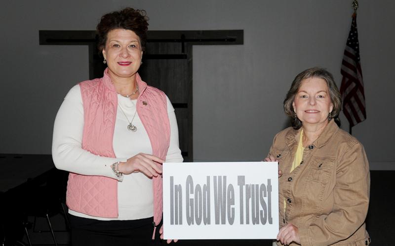 B. Alison Sosebee, left, and Sherry Morris display one of the signs meant to convey messages of help and hope during the COVID-19 pandemic.