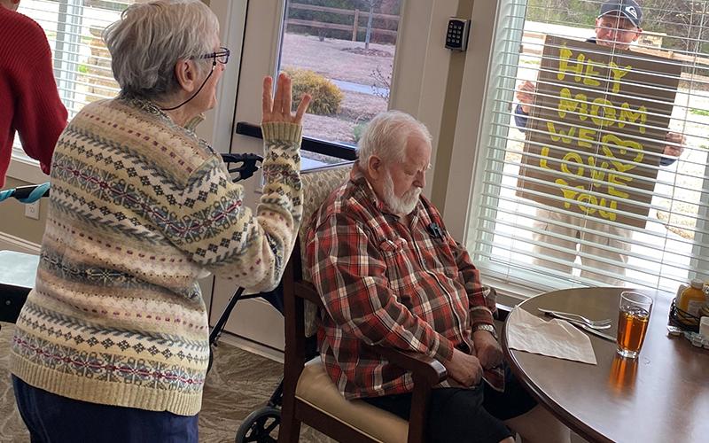 Blue Ridge Assisted Living &amp; Memory Care resident Carolyn Pierce waved to her sons, Jeff and Ryan Pierce, who made signs to cheer her up from afar.