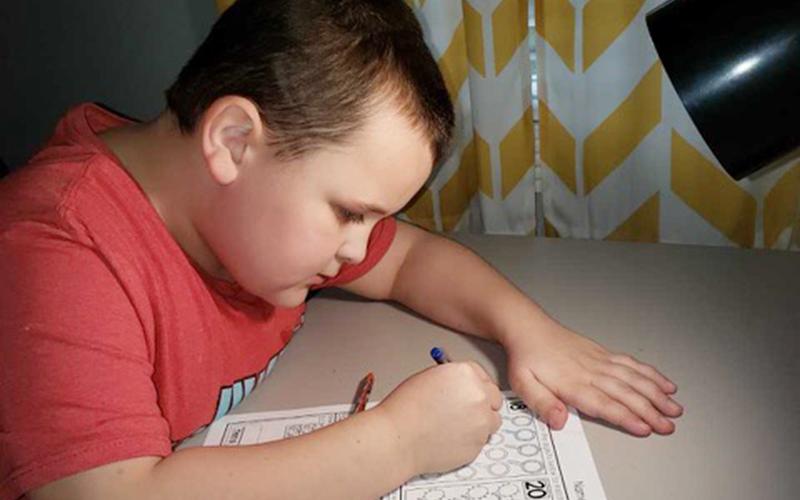 Blue Ridge Elementary School student Izaiah Bradburn works diligently at home to complete his school work while school is out.