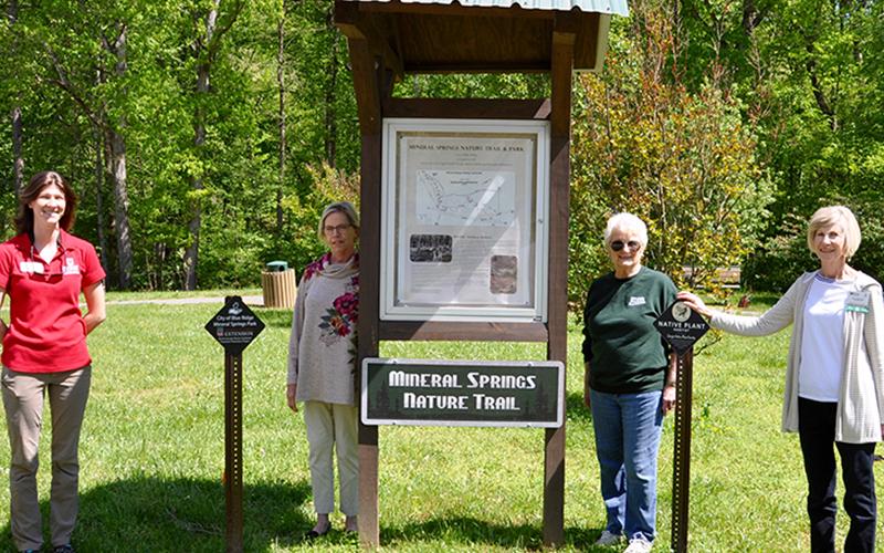 Standing beside the new signage at Mineral Springs Park in Blue Ridge are, from left, Fannin County Extension Agent Ashley Hoppers, North Georgia Master Gardeners Extension Volunteers (NGMGEV) Project Chair Alyce Wirtz, NGMGEV Wanda Jefferson and NGMGEV President Fran Stoecker.
