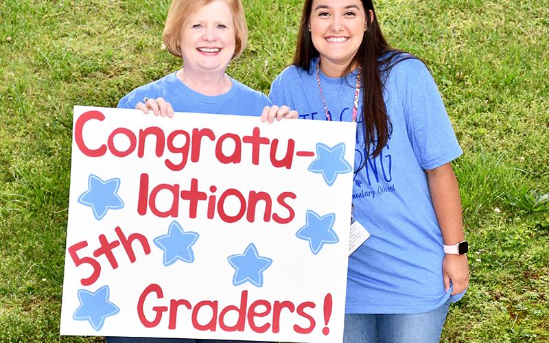 Blue Ridge Elementary School Art/Music/Drama Teacher Nancy Watkins, left, and Pre-K Teacher Sarah Adams congratulate fifth graders during the school’s Fifth Grade Drive-Thru Parade Tuesday, May 19.
