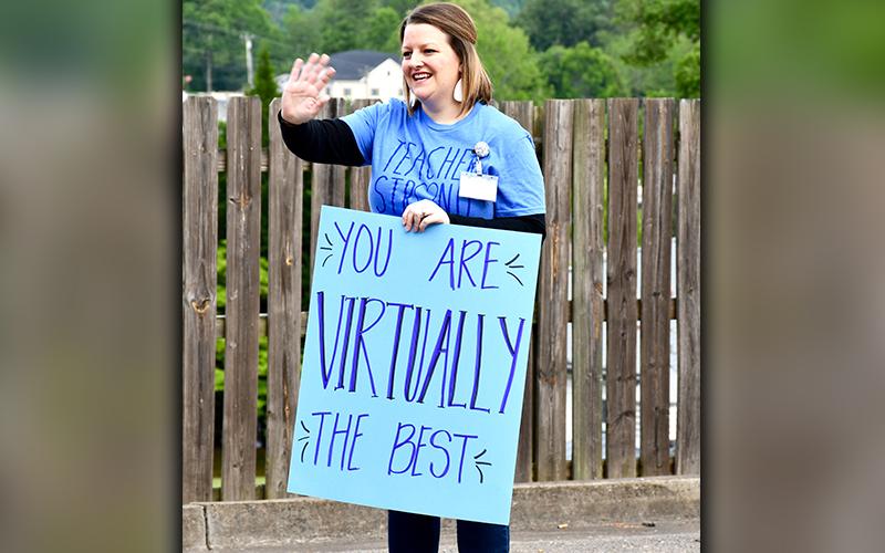 Blue Ridge Elementary School Counselor Trista Ragsdale waves to fifth grade students as they drive through the parent pick-up section at the school.