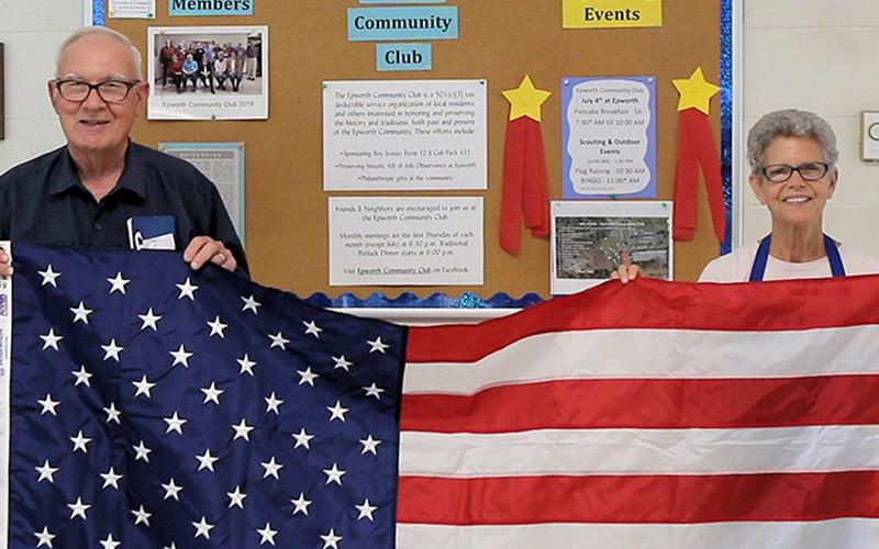 Garnett Webb is shown with his wife, Eugenia, after winning an American Flag at Epworth’s 4th of July event last year. The two are described as “quite the pair” and  annually entertained at veterans parties as Webb would sing Christmas carols while his wife played the piano.