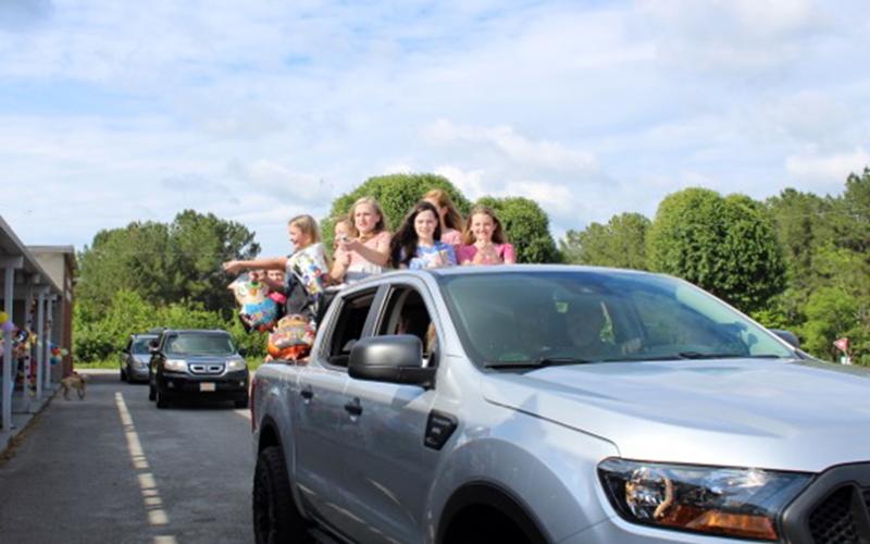 A truck load of sixth grade graduates smile and wave to teachers during Copper Basin Elementary’s sixth grade graduation Tuesday, May 26.
