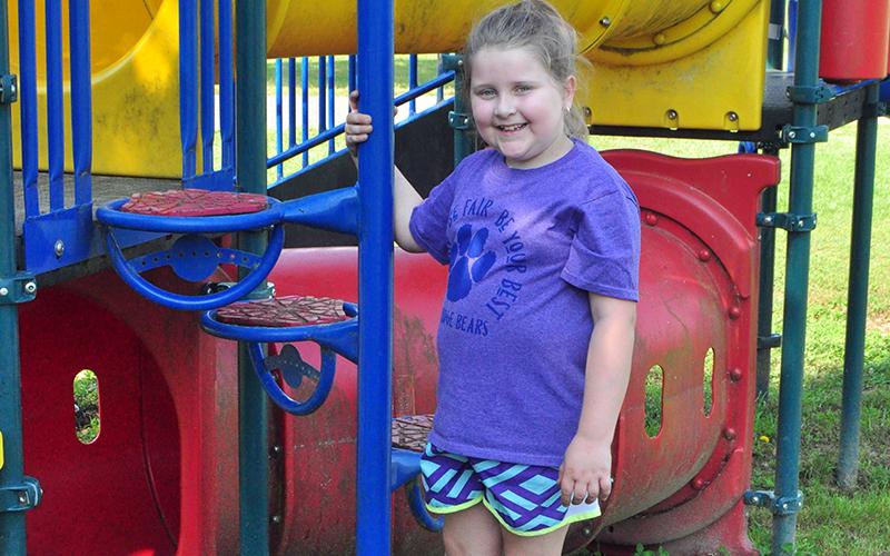 Lucy Mathis takes a break from playing on the playground to smile for a photo at the Fannin County Recreation Department’s Summer Camp Wednesday, June 3.