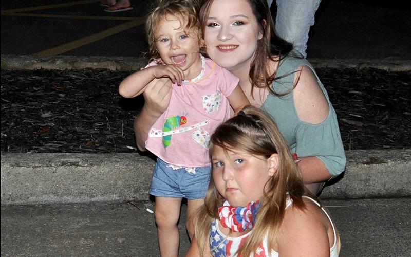 Naveah Swanwpoel, front, and Lakelynn, left, and Aaliyah Mitchem found a spot on the ground to watch Ducktown’s annual fireworks show.