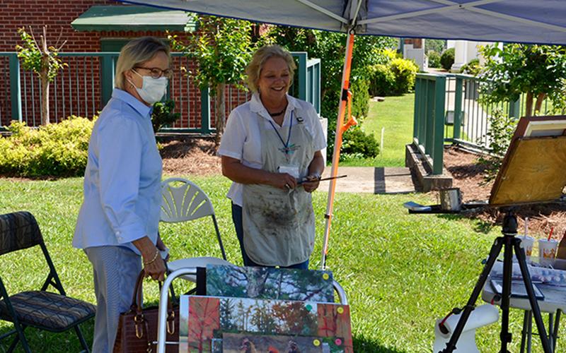 Fine Artist Camille Day, right, talks with Alyce Wirtz outside of the Smithsonian Institute’s Museum on Main Street opening of Crossroads: Change in Rural America at The Art Center Saturday, June 20.