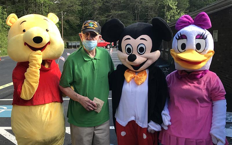 PruittHealth - Blue Ridge held a socially distanced drive-thru parade to lift the spirits of their residents Monday, May 25. Chuck Fenn is shown with characters: Winnie the Pooh, Mickey Mouse and Daisy Duck.