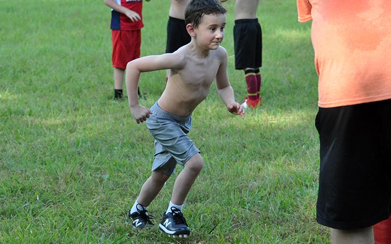 Kayson Coleman charges a tackling dummy during the Cougar’s five and six year old football conditioning Thursday, July 16.