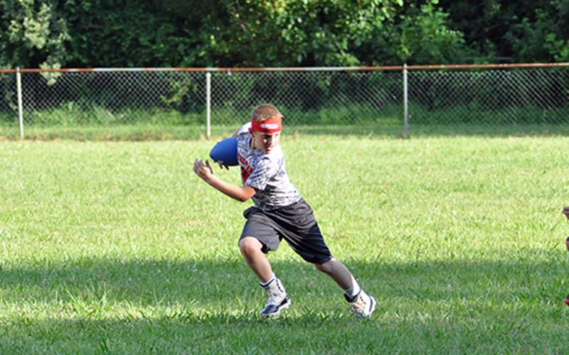 Donny Waters avoids a defender during the Copper Basin youth sports football conditioning Thursday, July 16.