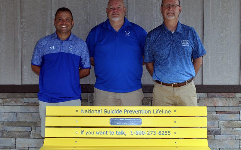 Josh’s Benches for Awareness Corporation recently donated a bench to the Fannin County Recreation Center. The bench provides the easily accessible hotline number for those needing help. Shown with the bench are, from left, Recreation Center athletic coordinators Tim Towe and John Spargo and Recreation Center Director Eddie O’Neal.