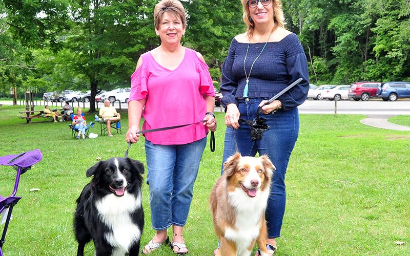 Everyone enjoys a summer evening at Pickin' in the Park. Joanie Baker, left, walks Jesse while Dawn Foster walks Shadrach during the first weekly event of the season July 9 at Ron Henry Horseshoe Bend Park. Everyone is invited to come out and enjoy the music and no electric instruments are allowed.
