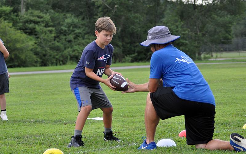 Braxson Newton practices at the quarterback position during football practice Tuesday, July 21.