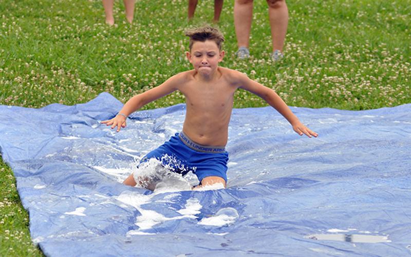 Reece Hughes slides down the slip-n-slide Wednesday, July 8, at the Fannin Recreation Center’s summer camp.