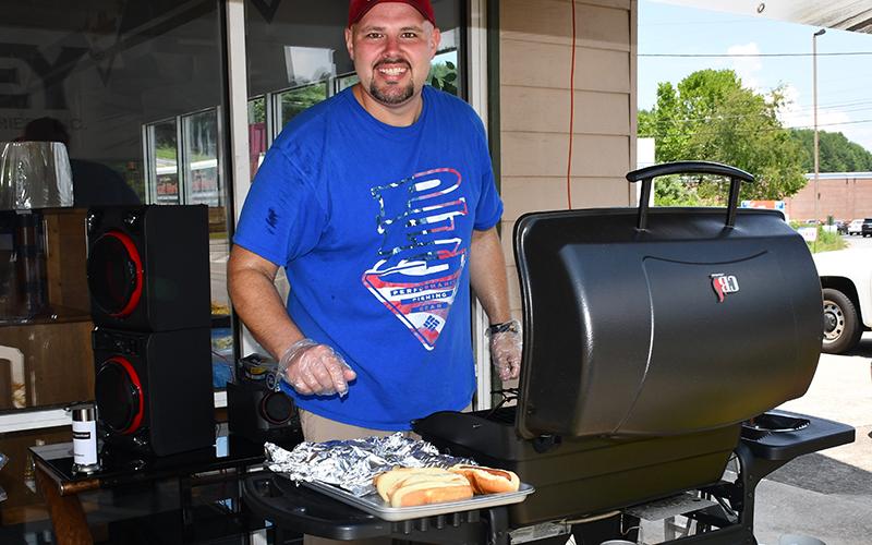Jeremy Wright grilled hot dogs for attendees of the Cars for a Cause car show fundraiser hosted by Lovin Racing and Circuit World to benefit Fannin County Family Connection Sunday, July 19.