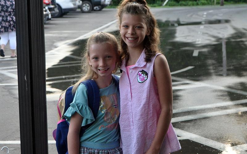 Fourth grader Desiray Park, left, and fifth grader Trinity Parker smile as they go to class during the first day of school at West Fannin Elementary School Friday, August 7.
