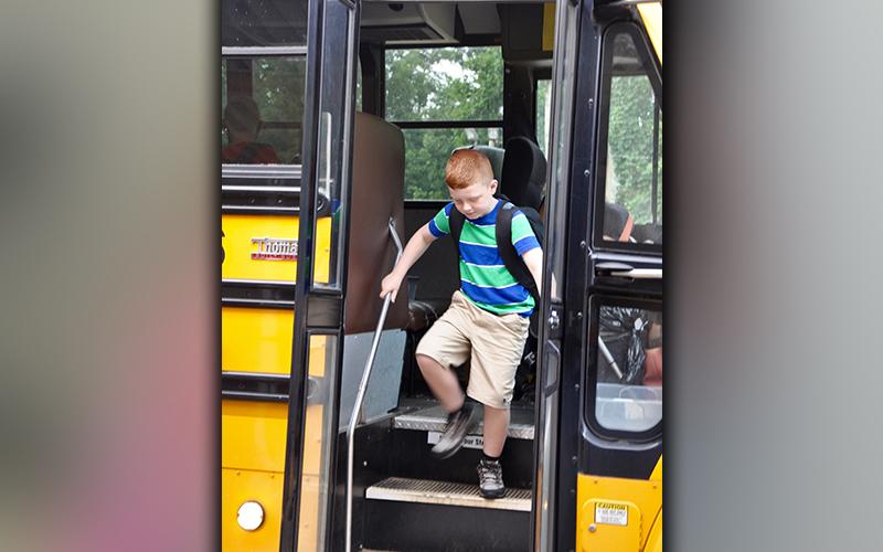 Zeke Payne shuffles to get off of the school bus at Blue Ridge Elementary School on the first day Friday, August 7.
