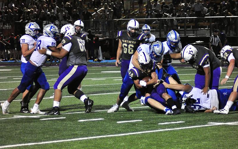 Micah O’Neal (52), Cason Owensby (22) and Logan Long (92) stop  a Union County ball carrier during the Rebels 24-20 win over the Panthers Friday, September 4.