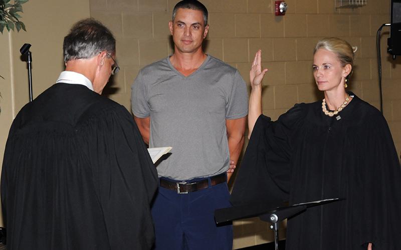 Polk County General Sessions Judge Brooklyn Townsend takes her oath of office from Circuit Court Judge Mike Sharp as her husband, Chris, looks on. Townsend was elected to serve the last two years of the unexpired term of Bill Baliles.