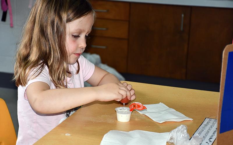 West Fannin Elementary School student Cecilia Bednarz dips her heirloom tomato in a cup of ranch as she and her fellow classmates try the tomato, some for the very first time.