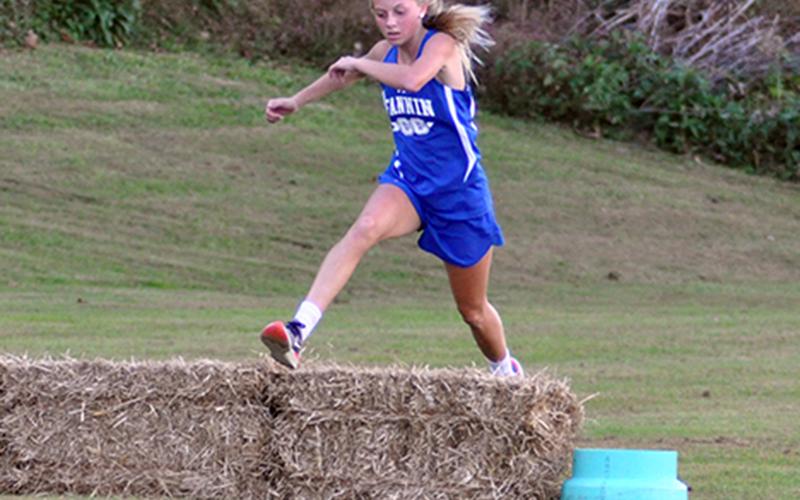 Carlee Holloway hurdles an obstacle during the Lady Rebels cross country meet Wednesday, October 21.