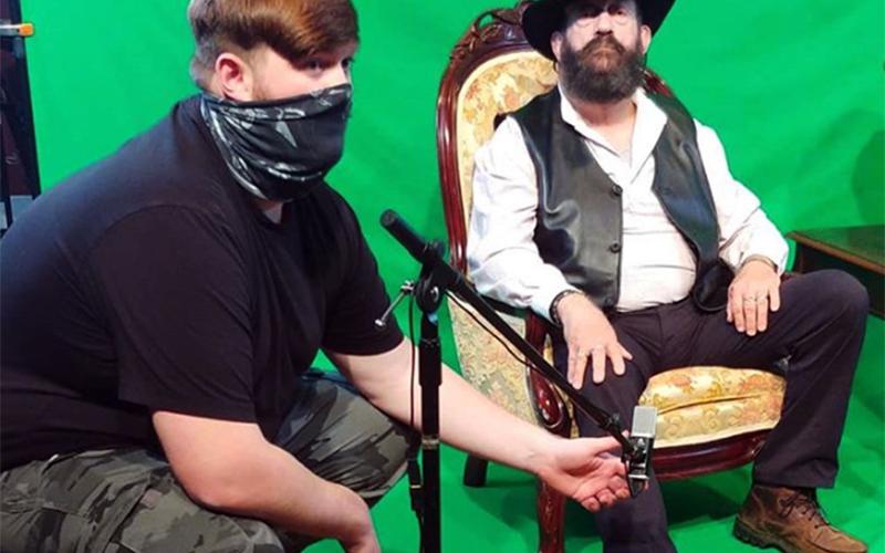 Boom operator Jackson Phillips checks the audio levels while Blue Ridge Community Theater President of Main Stage Michael Lacy sits before the green screen before filming.