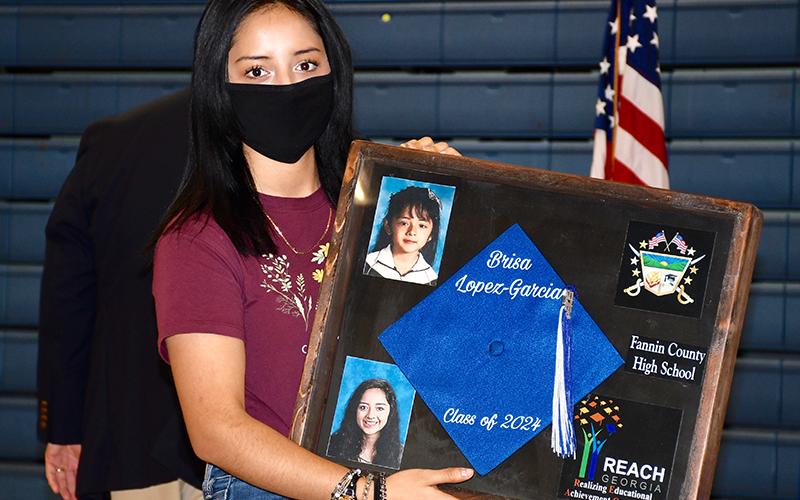 Fannin County High School Freshman Brisa Lopez-Garcia displays her Realizing Educational Achievement Can Happen (REACH) shadow box during the Signing Ceremony.