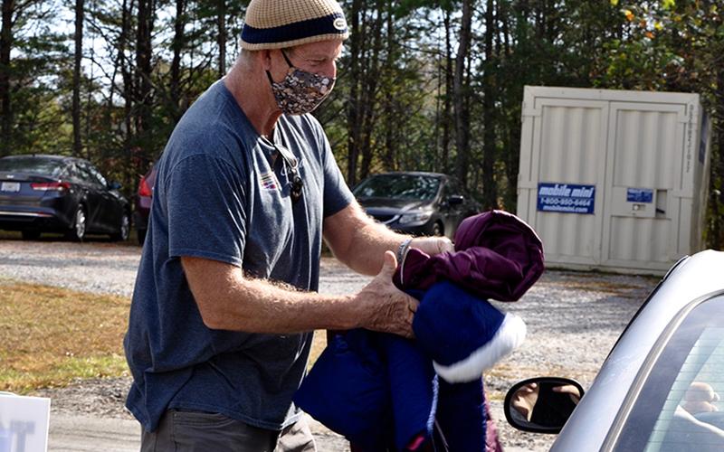Fannin County Family Connection volunteer John Rutland hands off some coats raised through The New Observer’s annual Coats for Kids coat drive Thursday, November 5, at Family Connection’s facility.