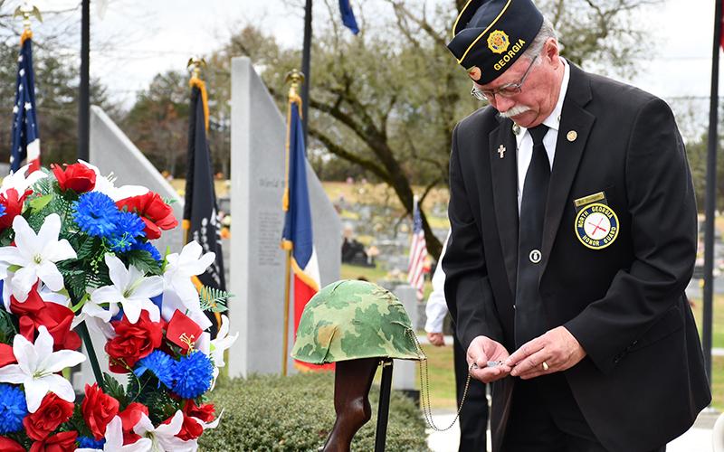 North Georgia Honor Guard Commander Bill Stodghill looks at the dog tags of fallen soldier during Fannin County’s Veterans Day ceremony Saturday, November 7.