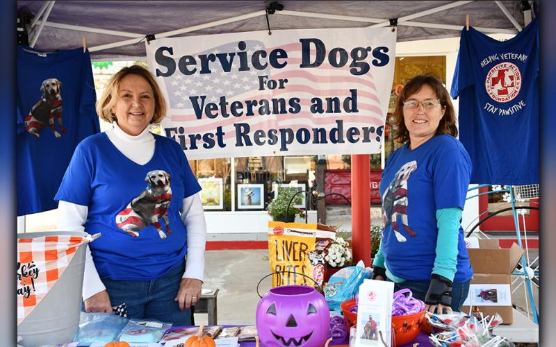 Pawsitive Action Volunteer Amy Ulrich, left, and Founder Norma Ross promote the non-profit’s mission to provide service dogs to veterans in the community during an event Saturday, October 31.