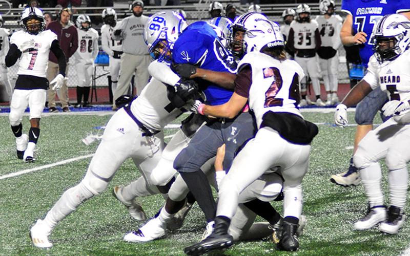 Jalen Ingram (88) powers his way through a host of Braves during the Rebels playoff win against Heard County Friday, December 4.