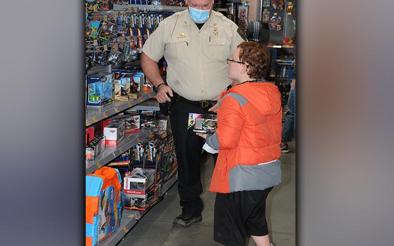 Fannin County Deputy Sheriff Corporal John Kinser helps a youngster pick out the perfect Christmas gift during Shop With a Cop. A total of 87 children were served by the program this year.