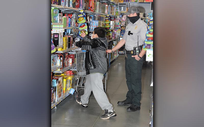 Choosing a Christmas gift isn't always easy for youngsters taking part in Shop With A Cop. This young man was helped Saturday by Department of Natural Resources Sergeant Cody Long.